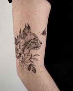 a woman's thigh with a tattoo of a wolf and flowers on it