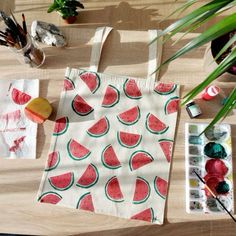 a watermelon bag sitting on top of a wooden table next to other items