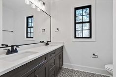 a bathroom with two sinks and a large mirror above the sink is shown in black and white