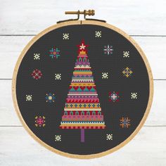 a cross stitch christmas tree on a black background