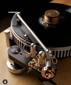 an old record player sitting on top of a wooden table