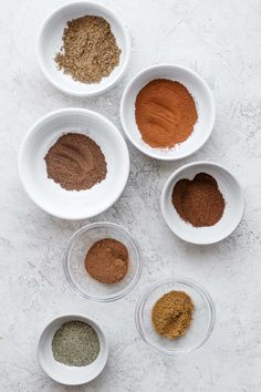 four bowls filled with different types of spices