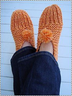 someone is wearing knitted slippers with pom - poms on their feet