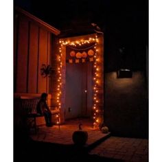 a person sitting on a bench in front of a door decorated with lights and decorations