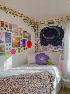 a bedroom with posters on the wall and a leopard print bed spread in front of it