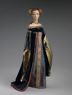 a figurine is dressed in an elaborate blue and gold dress with golden trim