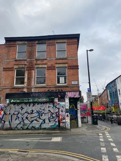 an old brick building with graffiti on it's side next to a street corner