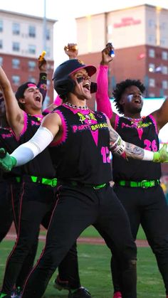 a group of people that are standing in the grass with their arms up and hands out