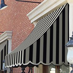 an awning on the side of a building next to a street light and lamp post