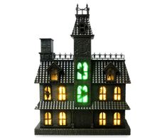 a lit up house with windows and a clock on the front is shown against a white background