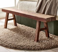 a wooden bench sitting on top of a shaggy rug