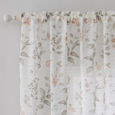 the curtain is hanging on the rod with flowers and leaves painted on it's side