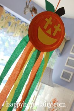 an orange and green paper decoration hanging from the ceiling