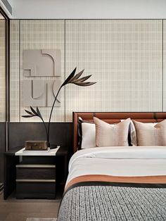 a bedroom with a bed, nightstands and paintings on the wall behind it in neutral colors