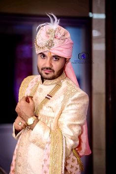 a man wearing a pink turban and gold jewelry