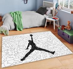 a bed room with a bed and a large rug on the floor that has a basketball player silhouette on it