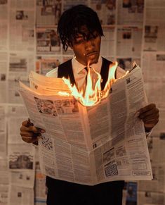 a man reading a newspaper with flames coming out of his face and hands behind him