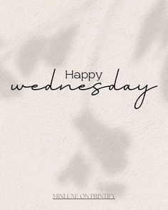 a white wall with the words happy wednesday written in cursive writing on it