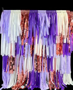 colorful streamers are hanging from the side of a wall in front of a black background