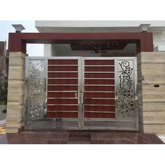 an entrance to a house with metal gates and decorative designs on the front door,