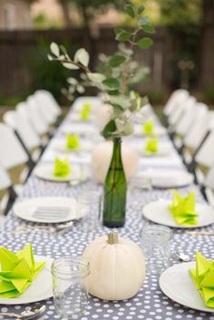 a long table with white plates and green napkins