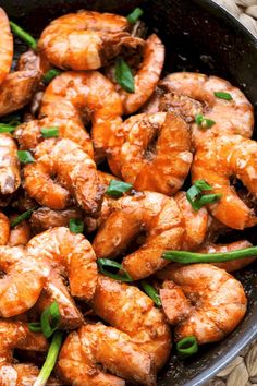 cooked shrimp in a skillet with garnishes