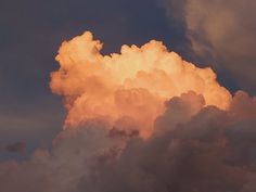 an airplane is flying through the clouds at sunset