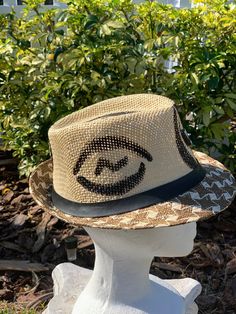 This is a great fedora for your hat collection. It's artful and stylish. The hand painted fedora has Gyname prosperity symbols on It. The wearable Art fedora is a must have. Don't delay order yours today. Artistic Adjustable Hat Bands For Fedora, Adjustable Artistic Fedora For Festival, Artistic Adjustable Fedora With Short Brim, Artistic Adjustable Brimmed Panama Hat, Artistic Fedora With Adjustable Fit And Short Brim, Artistic Adjustable Fedora Sun Hat, Artistic Adjustable Fedora For The Beach, Adjustable Artistic Fedora Sun Hat, Artistic Brimmed Fedora For The Beach