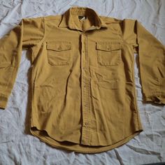 Vintage Deerskin Mustard Yellow Button-Front Long-Sleeve Utility Shirt Would best fit size L/XL Excellent condition Brown Long Sleeve Shirt With Buttons, Shirt With Buttoned Pockets For Fall, Fall Shirt With Solid Color And Buttoned Pockets, Solid Shirt With Buttoned Pockets For Fall, Khaki Long Sleeve Tops With Buttoned Pockets, Solid Winter Shirt With Button Closure, Solid Winter Shirt With Buttons, Classic Long Sleeve Tops With Buttoned Pockets, Long Sleeve Cotton Shirt With Snap Buttons