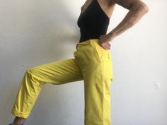 "Vintage pants Levi's LVC Big E Reedition 1990's Cotton chino pants in yellow color. Straight cut. Hook closure with zip. 7 belt loops. 2 front pockets, 2 buttoned back pockets. Tighter ankles with hamstitch. Red label on back waistband. Material: 100% cotton (no label) Condition: Vintage item in very good condition. To note: 3 small spots are present (photo). Price takes into account its flaws. Size: 28 Model wears usually a size S (36/38) and measures 170cm / 66.9\". Measures taken flat : Leng Stretch Yellow Cotton Bottoms, Yellow Stretch Cotton Bottoms, Yellow Cotton Stretch Bottoms, Yellow Stretch Tapered Leg Bottoms, Vintage Wide Leg Yellow Pants, Retro Yellow Pants With Pockets, Yellow Cotton Cargo Pants For Summer, Vintage Wide Leg Yellow Bottoms, Yellow Tapered Leg Bottoms For Spring