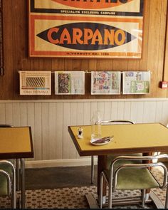 the interior of a restaurant with wooden paneling and yellow tables in front of it