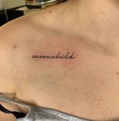 the back of a woman's shoulder with an inscription on it that reads, moonchild