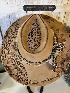 Beautiful sunflowers with a lot of leopard print.  This hat is 100% Custom hand burned suede hat that is created and made by myself. Measurement: 3.75 inches (9.5 cm) wide-brimmed suede western hat. One size fits most ladies: 22 - 23 inches (56-58 cm) Inner Circumference.  Message me if you would like to add a name, date, or special saying.  Keep in mind this hat is unique to its own due to I hand burn myself. So each hat is not identical but very close.  Message me with any questions you might Wide Brim Cowboy Hat, Wood Burned Hats Women, Burned Hats For Women, Felt Hat Burning Designs, Custom Cowgirl Hats, Hand Painted Hats