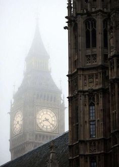 the big ben clock tower towering over the city of london on a foggy day