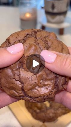 a person holding a chocolate cookie in their hand