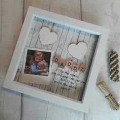 a photo frame with two hearts hanging from it's sides and the words daddy written on it