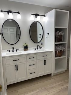 a bathroom with double sinks and two mirrors on the wall next to eachother