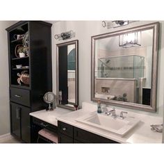 a bathroom with two sinks and a large mirror on the wall above it's cabinets