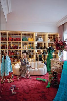 a woman sitting on top of a white couch in a room filled with lots of shoes