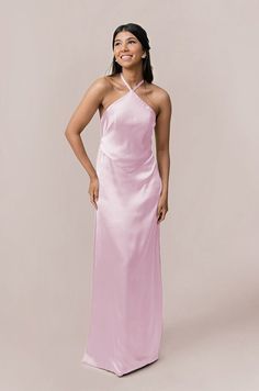 a woman in a long pink dress posing for the camera with her hands on her hips