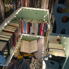 a bookshelf filled with lots of books next to a pile of stuffed animals