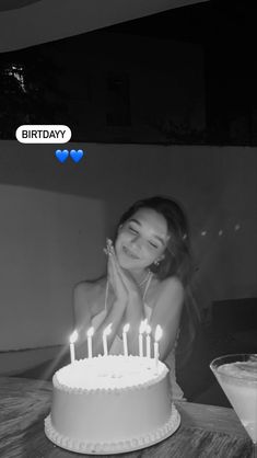 a woman sitting in front of a birthday cake with candles on it and the caption happy birthday