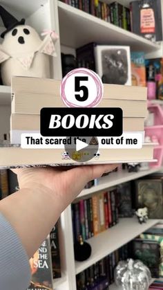 a person holding up a stack of books with the title 5 books that scared out of me