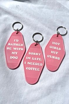 three pink key chains that say i'd rather be with my dog, i'm late, i need coffee