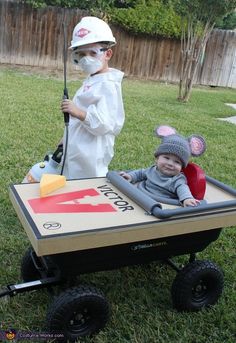 a baby in a wagon with a mouse on it and another child dressed up as mickey mouse