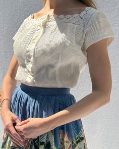 This vintage 1950s blouse looks like something you would find made by hand in Provence many moons ago. It is so beautifully made of a crisp cotton-blend poplin, with pintucks through the front of the blouse, and crochet lace trim. Darts and shaping seams create a fitted shape with a nipped waist, but it can also be worn more loosely fitting (as shown). It looks cute tied in the front as well! It closes down the front with pretty mother-of-pearl-esque orb buttons, which look really luxe. The Vint Provence Fashion, 1950s Blouse, French Lady, Vintage Blouses, Find Style, Skirt Measurements, Blouse Measurement, Crochet Lace Trim, Making Things