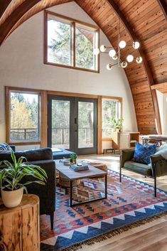 a living room filled with lots of furniture next to a wooden ceiling covered in windows