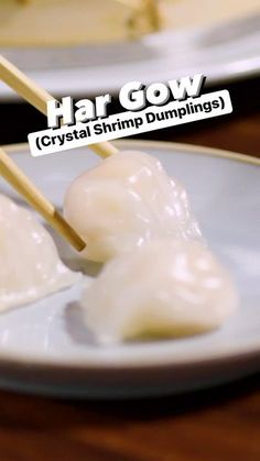 two white plates topped with dumplings and chopsticks on top of each other