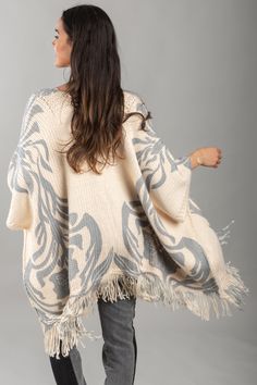 A chic and comfy layering piece, the Elora Knit Tassel Kimono displays floral and leaflet motifs, fringed edges, and is made from soft fabric that will keep you cozy this fall and winter. It is designed to rest comfortably on your shoulders and can be styled with the front open or fastened closed with a belt or pin for a more structured look. Material: Acrylic Size: 25" x 40" + 5.5" Fringe Winter Beige Fringe Shawl, White Fringe Shawl For Winter, White Fringed Winter Shawl, Beige Fringed Winter Shawl, White Fringed Shawl For Winter, Beige Fringed Shawl For Winter, Cream Bohemian Shawl For Fall, Beige Fringe Poncho For Fall, Kimono With Fringe