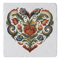 an ornate tile with flowers and leaves on white background, in the shape of a heart